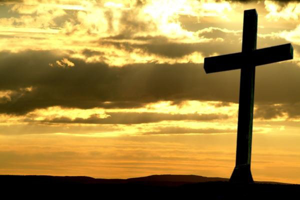 Cross silhouetted against a golden sky